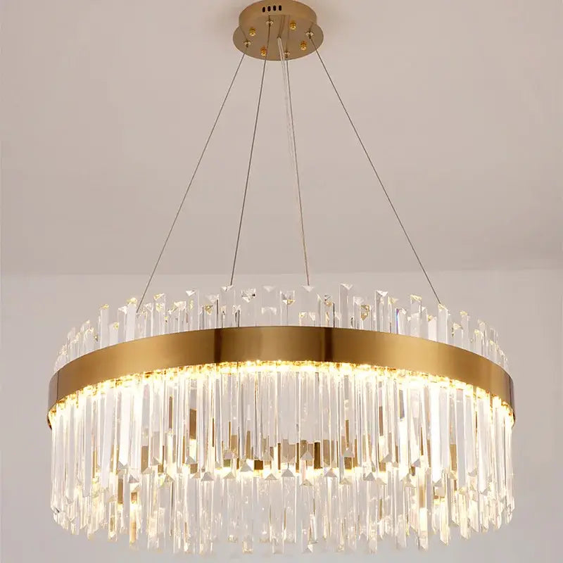 A modern decorbites crystal led chandelier with gold metal frame and cascading clear crystal prisms for dining room lighting