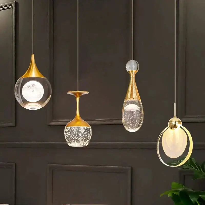 Four gold-toned decorbites crystal led pendant lights with clear glass vase-like shades for dining room chandelier