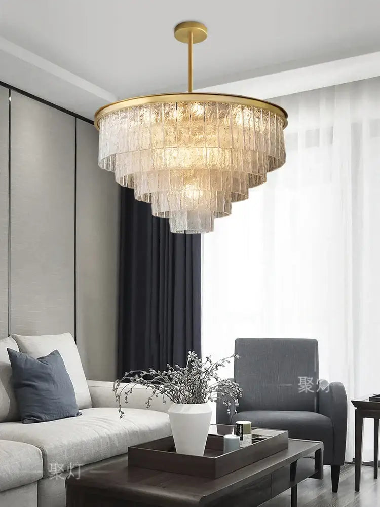 A decorbites crystal led chandelier with a gold finish and cascading textured glass layers for dining rooms