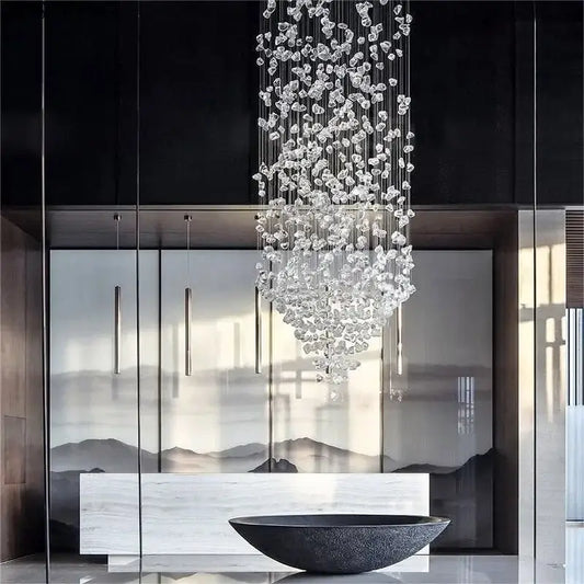 A cascading decorbites crystal led chandelier with clear faceted glass pieces suspended by thin metallic wires