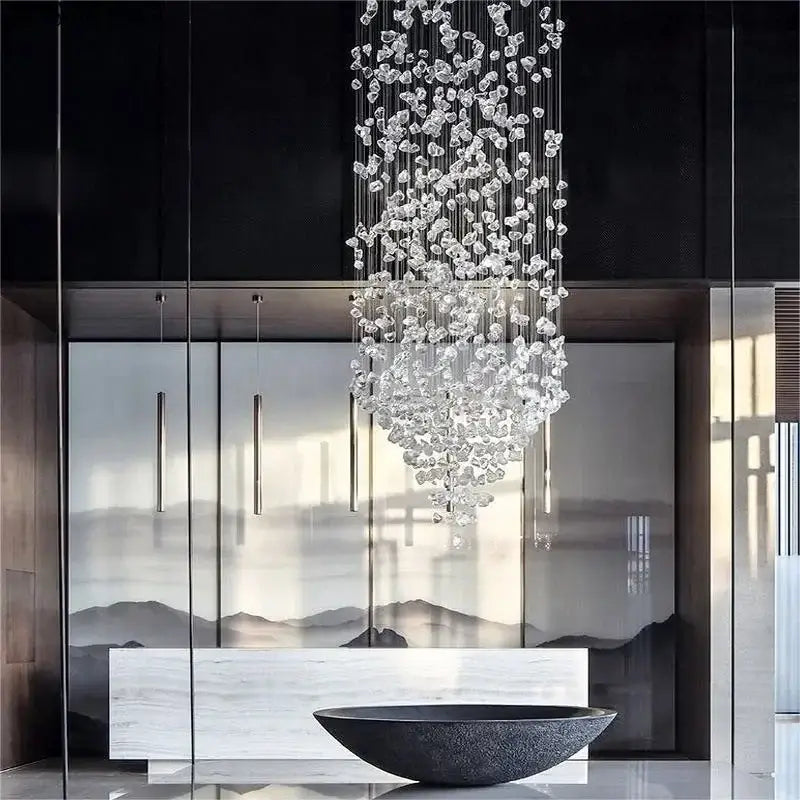 A cascading decorbites crystal led chandelier with clear faceted glass pieces suspended by thin metallic wires