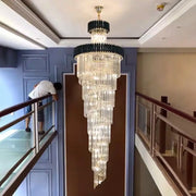 A decorbites crystal led multi-layer staircase chandelier with black and gold frame and cascading clear glass prisms