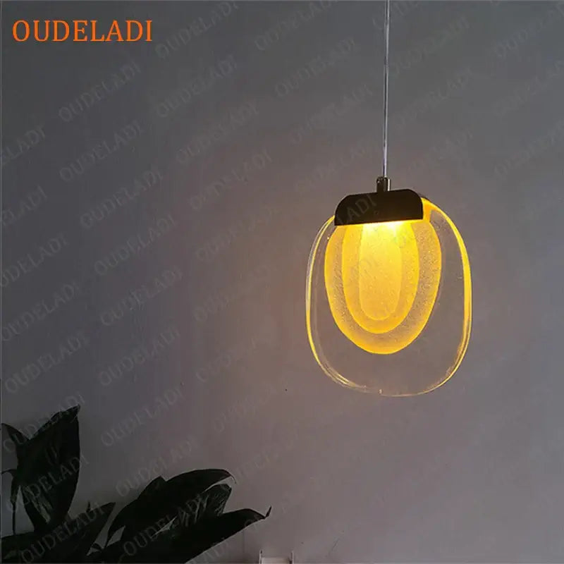A modern decorbites crystal led pendant light with a translucent yellow glass shade and black metal top suspended by cord