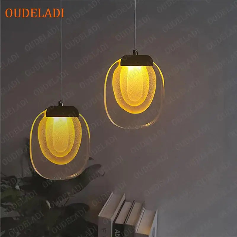 Two warm yellow decorbites crystal led pendant lights with clear glass oval frosted diffusers and black metal tops