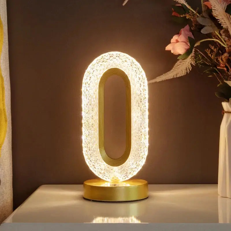Golden oval decorbites crystal led table lamp with glowing textured crystal design and sleek metallic base for bedroom use