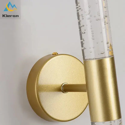 Gold-toned decorbites crystal led wall lamp with clear glass cylinder and floating bubbles for elegant bedroom decor