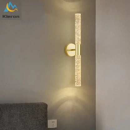 Gold-toned decorbites crystal led wall lamp with sparkling textured glass cylinder emitting warm light for bedroom decor