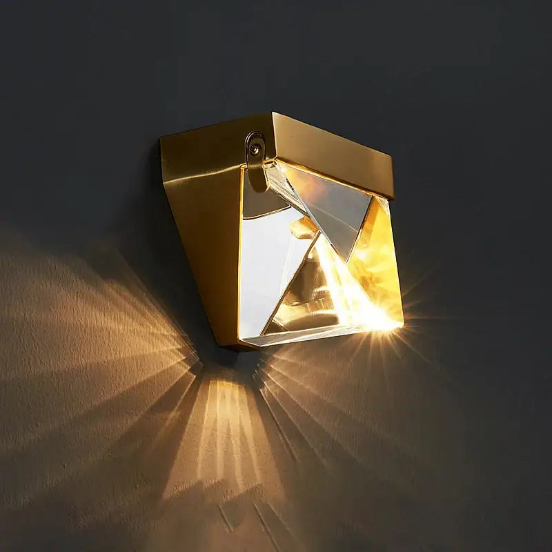 Modern gold crystal led wall sconce with geometric mirrored facets casting radiant light patterns for bedroom decorbites crystal led wall