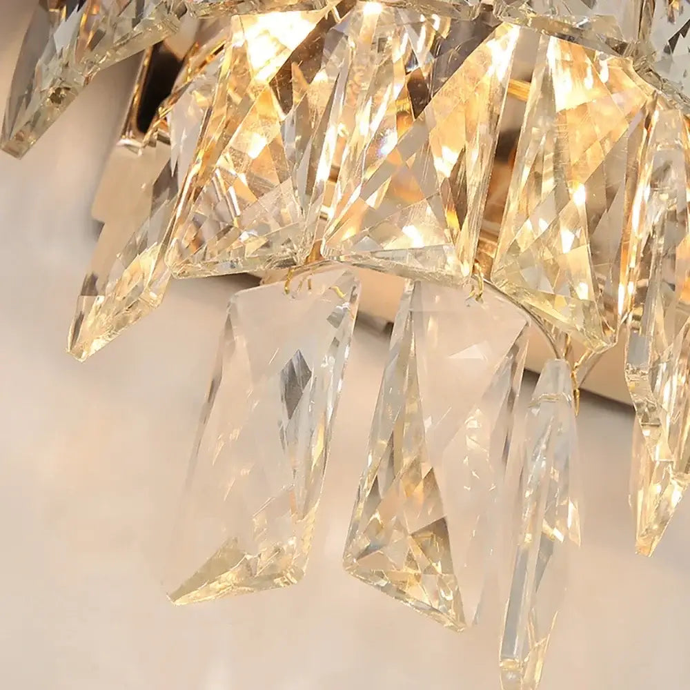 A crystal chandelier with clear glass prisms and gold frame showcasing modern black led wall sconces for bedroom lighting