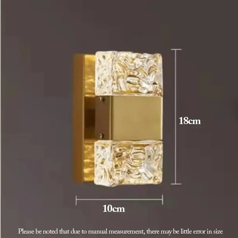 Modern textured gold-toned led wall sconce with clear glass panels featuring intricate floral patterns for bedroom use