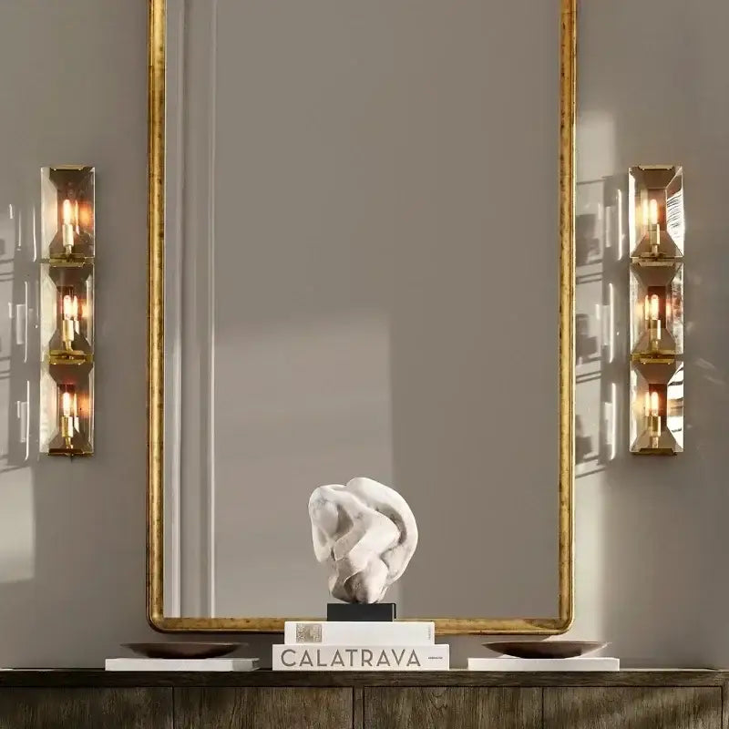 A white abstract sculpture with smooth flowing form on stacked books complements modern geometric decorbites crystal led wall sconces