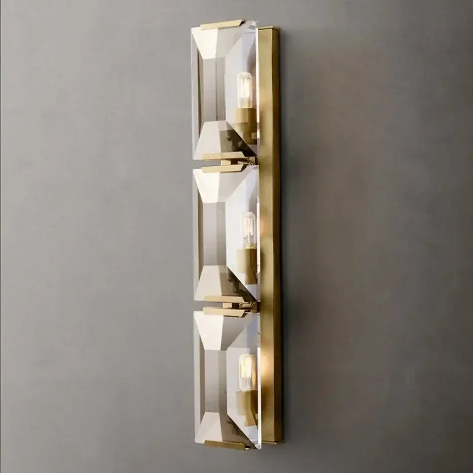 Gold-toned wall sconce with three clear faceted crystal shades and exposed bulbs from decorbites crystal led wall sconces collection