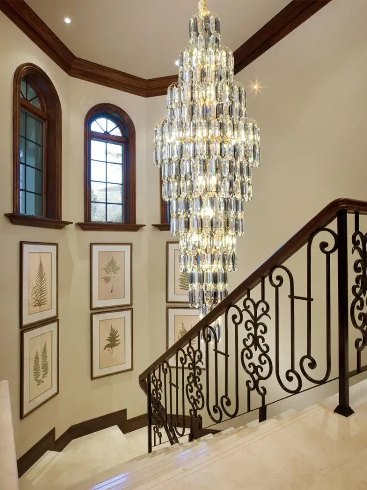 Crystal spiral tiered loft pendant light with faceted glass and golden metal frame hanging above staircase