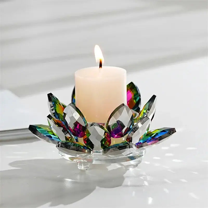 A colorful crystal lotus candle holder with iridescent faceted petals holding a lit white pillar candle for aromatherapy