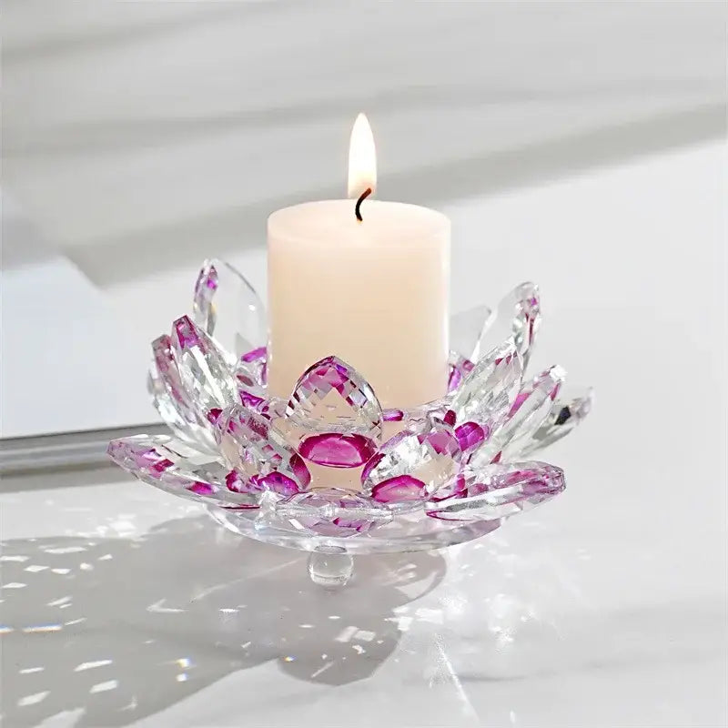 A clear crystal lotus candle holder with purple-tinged petals cradling a white pillar candle for aromatherapy