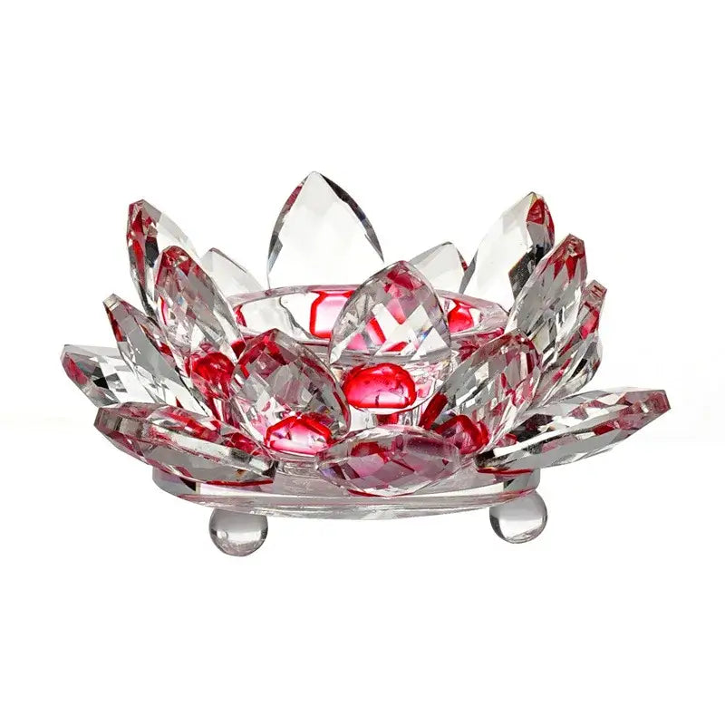 Crystal lotus-shaped candle holder with faceted petals and embedded red gemstones.