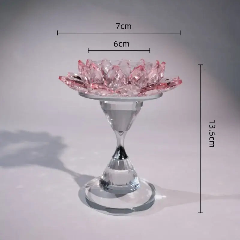 A delicate pink and clear crystal lotus candle holder with a glass stem and base for dining room decor