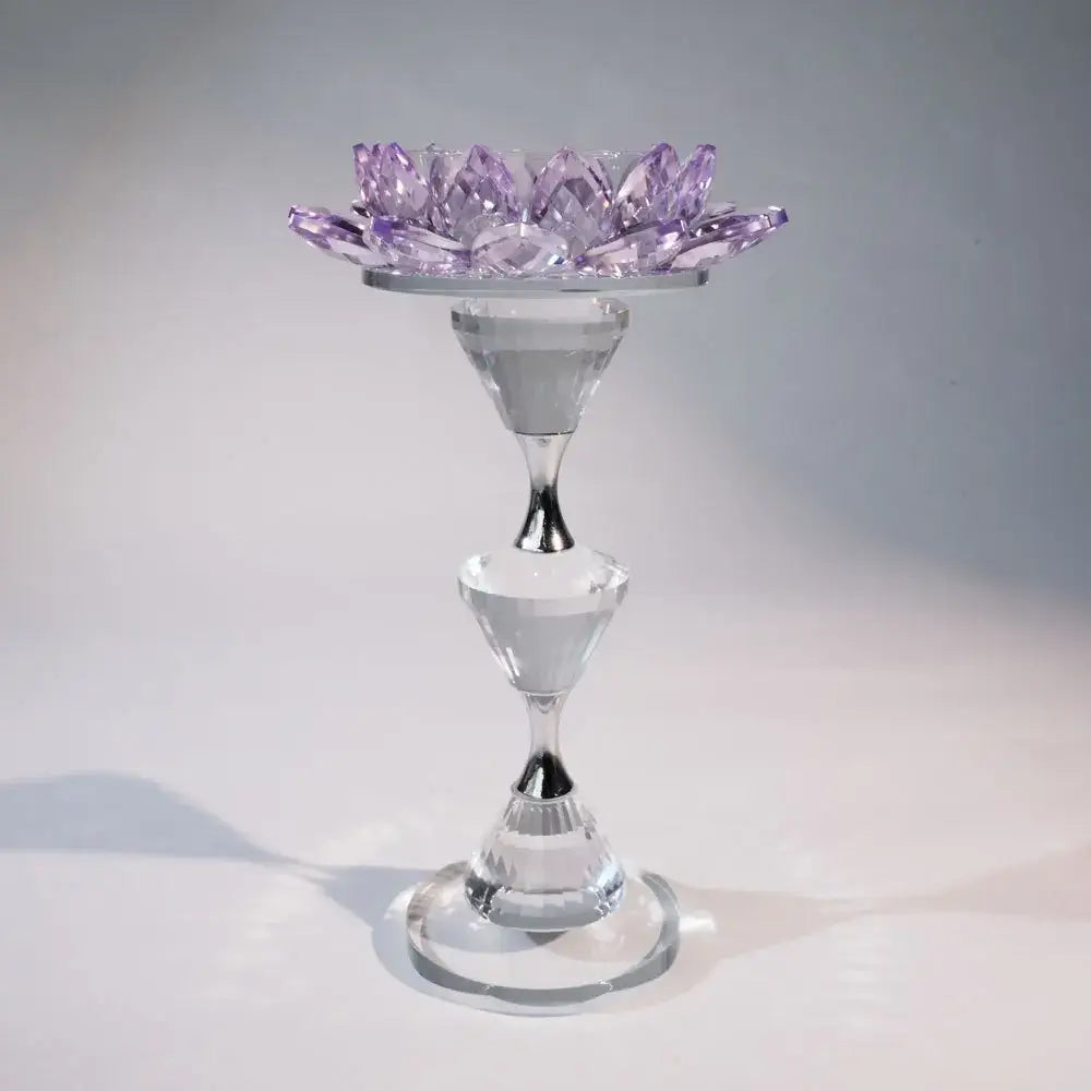 A translucent purple lotus candle holder sits on a clear faceted glass pedestal for dining room decor