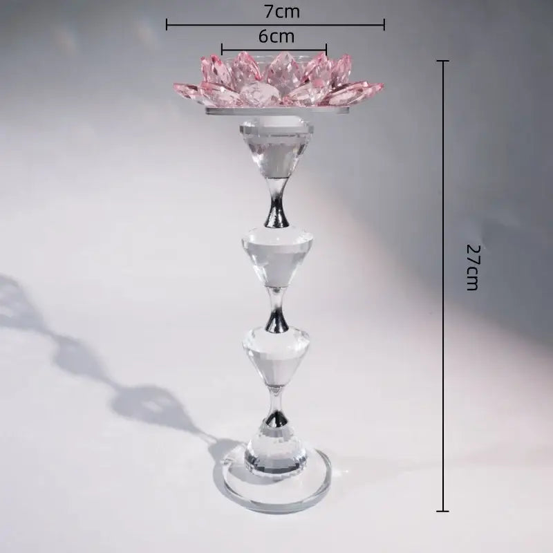A delicate pink and clear crystal lotus candle holder with glass tiers and silver accent for dining room decor