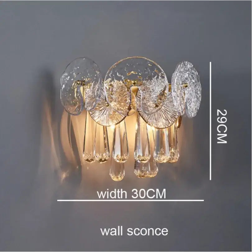 A nordic golden crystal lotus chandelier wall sconce with clear textured glass discs and dangling crystal teardrops