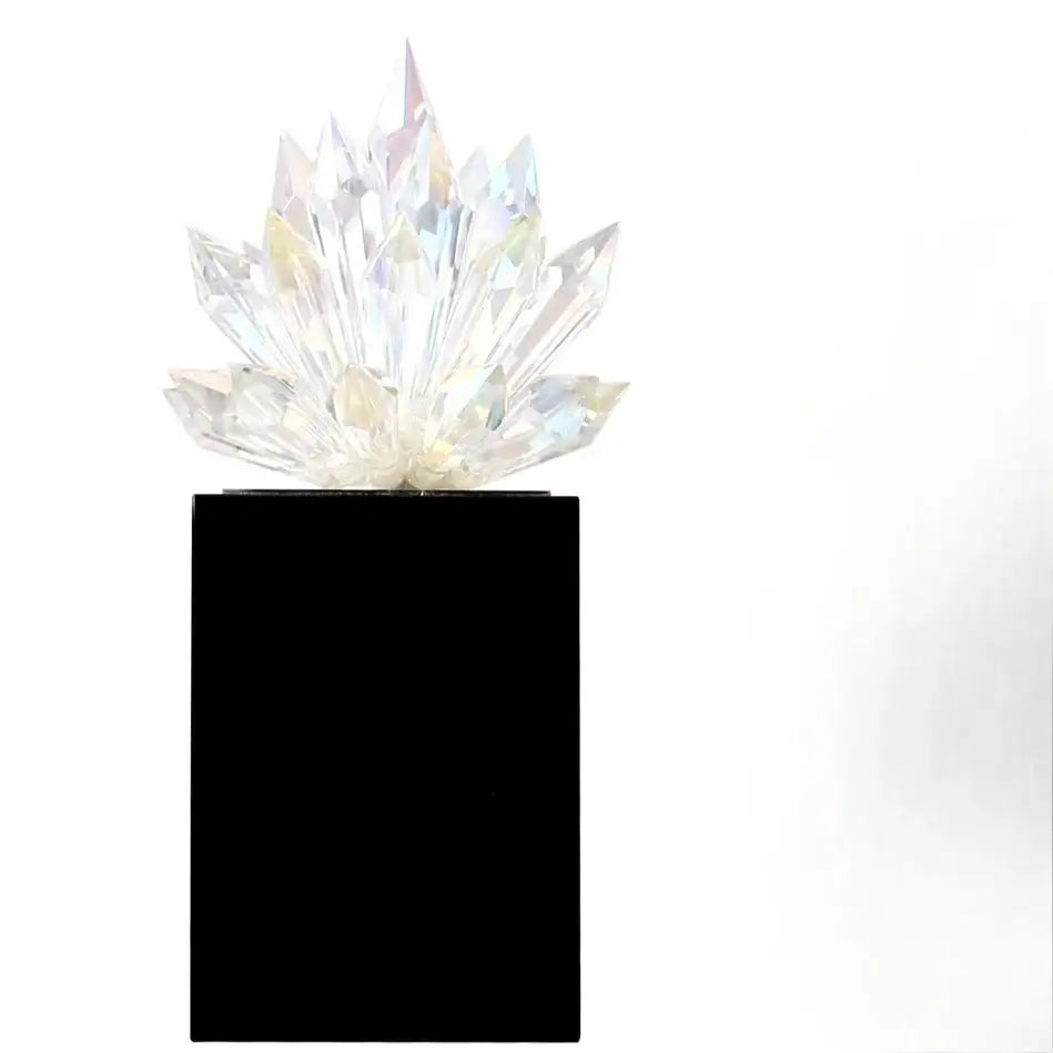 A translucent faceted crystal lotus tabletop decoration in clear iridescent glass on a sleek black base by decorbites