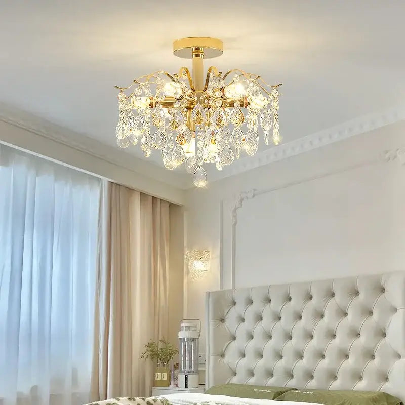 Gold-finished crystal luxe led chandelier with ornate arms and clear glass droplets for living room elegance