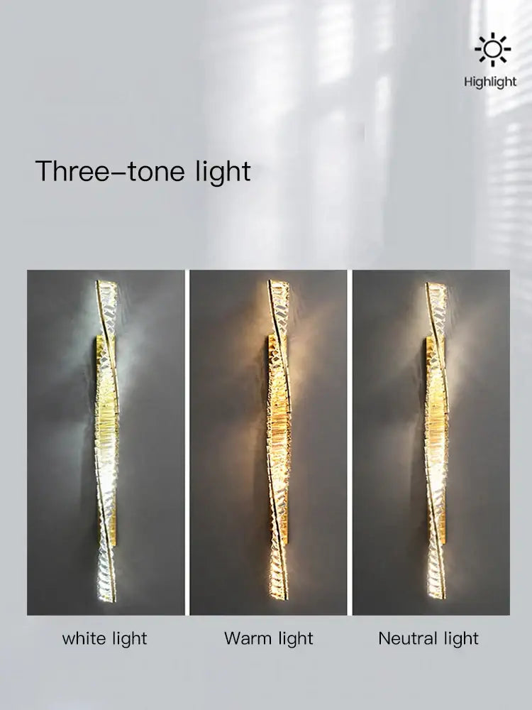 A sleek twisted luxe wall sconce with textured gold and silver finish emitting white warm and neutral light