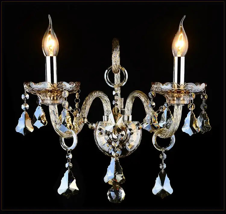Luxury gold crystal wall lamp with clear and amber glass droplets featuring two lit candle bulbs for luxury bedroom lighting