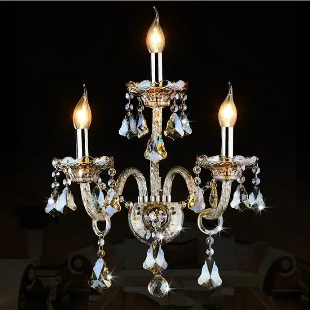 Elegant luxury bedroom wall lamp with gold-toned metal and dangling crystal droplets for sophisticated lighting