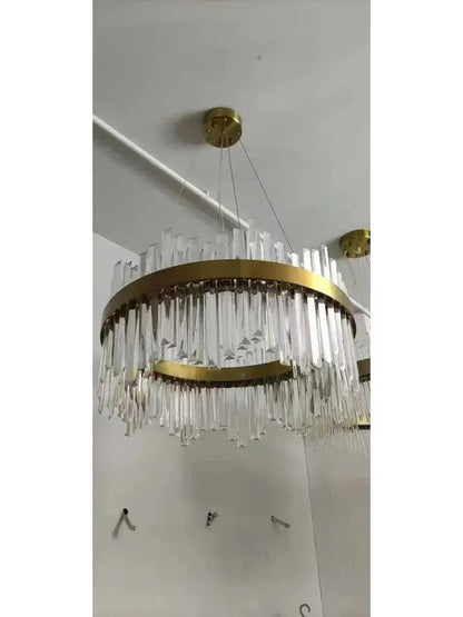 A modern decorbites™ crystal pendant chandelier with gold-toned metal rings and modest crystal rods for home decor