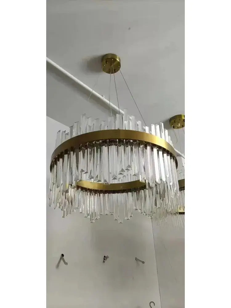 A modern decorbites™ crystal pendant chandelier with gold-toned metal rings and modest crystal rods for home decor
