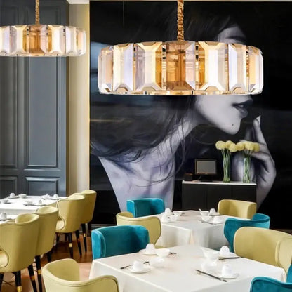 A modern decorbites crystal pendant chandelier with faceted crystal panels and gold frame for living room lighting