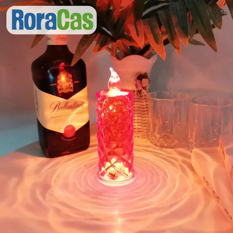 A glowing red decorbites crystal rose led night light candle with faceted crystal rose dioptric design and illuminated flame top