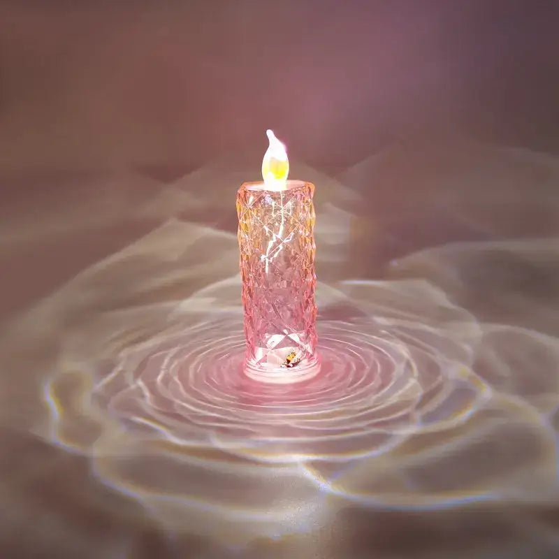 A translucent pink decorbites crystal rose led candle night light with faceted crystal rose dioptric design and flame