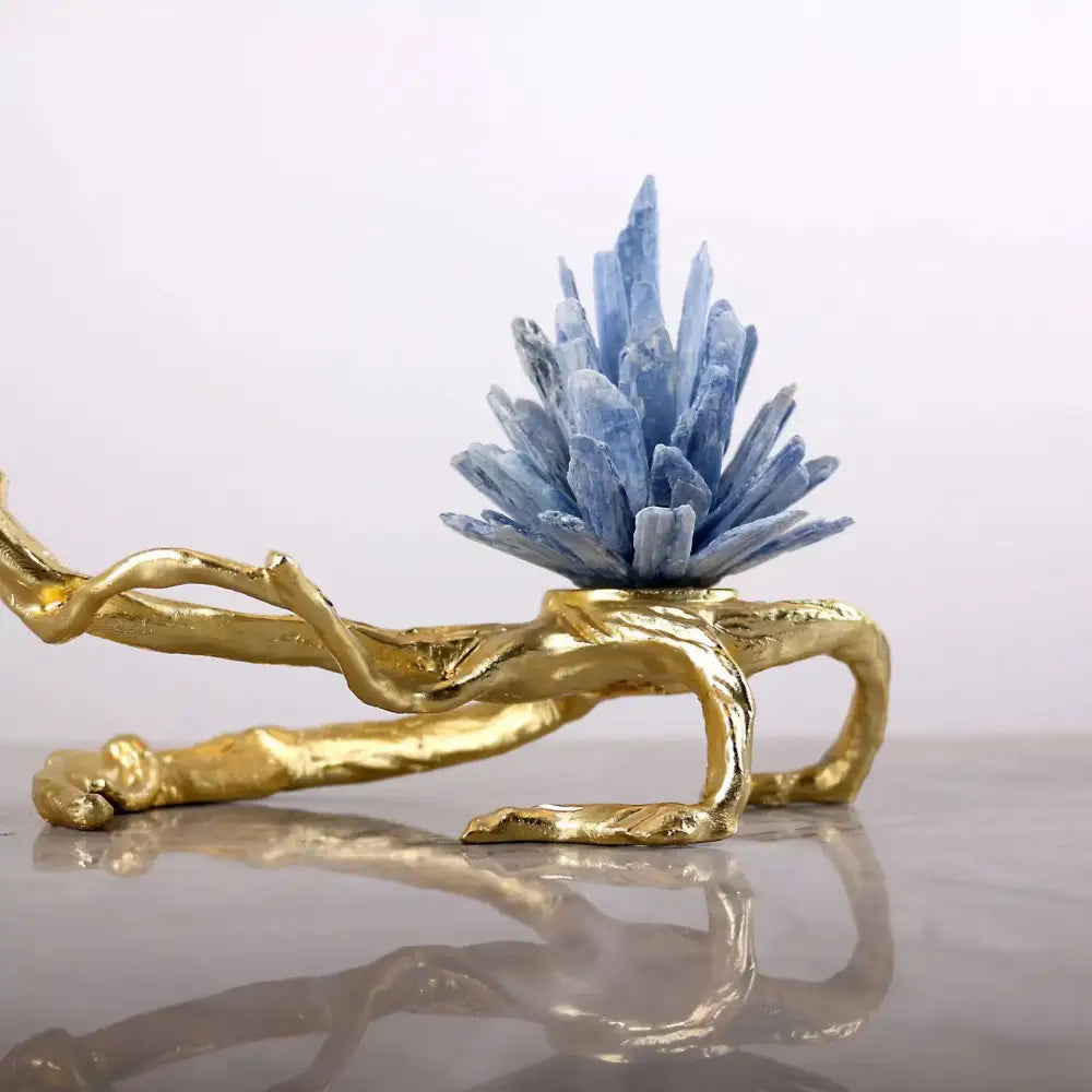 A striking blue apatite crystal stone golden bird sculpture on a golden branch base by decorbites for living room decor