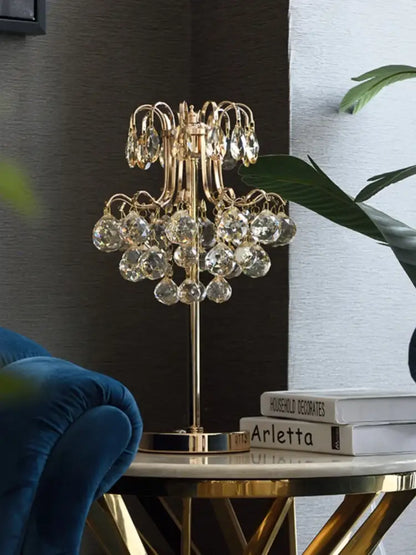 Gold-toned decorbites crystal table lamp with chandelier style and dangling faceted glass orbs for bedroom lighting