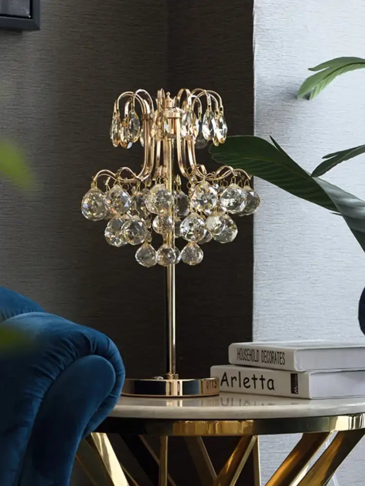 Gold-toned decorbites crystal table lamp with chandelier style and dangling faceted glass orbs for bedroom lighting