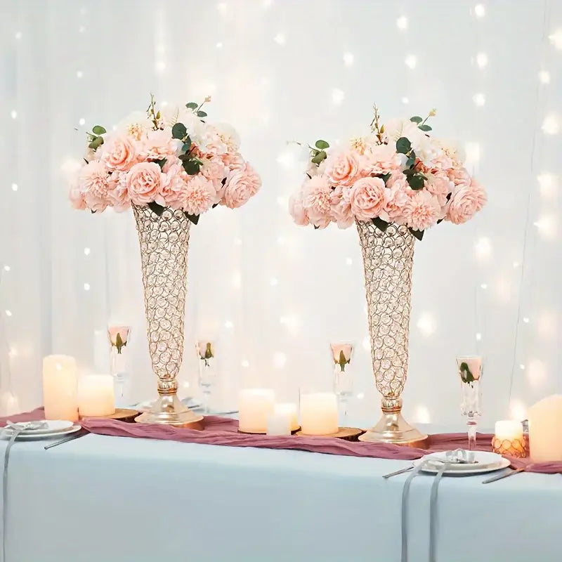 Two tall gold-toned metallic crystal vases with intricate lattice design hold pink roses for dining tables home decor