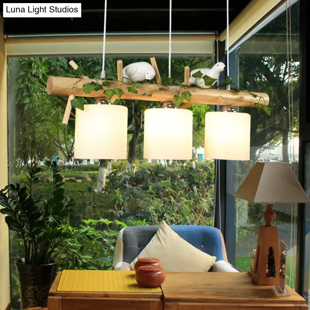 Decorbites natural wood branch pendant light with three cream cylindrical shades and white resin bird deco