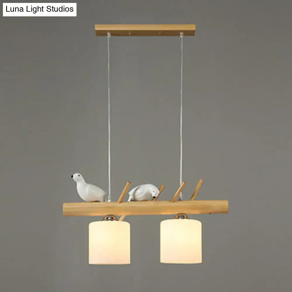 Decorbites cylindrical milk glass pendant light with resin bird deco on natural wood beam for country style restaurants
