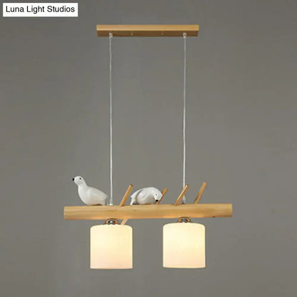 Decorbites cylindrical milk glass pendant light with resin bird deco on natural wood beam for country style restaurants