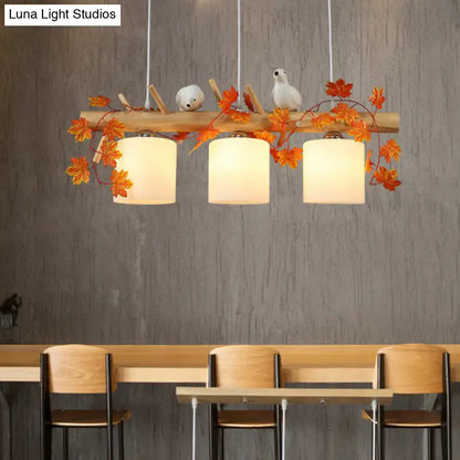 DecorBites™ rustic wooden pendant light with three white cylindrical shades and orange resin bird deco for country style