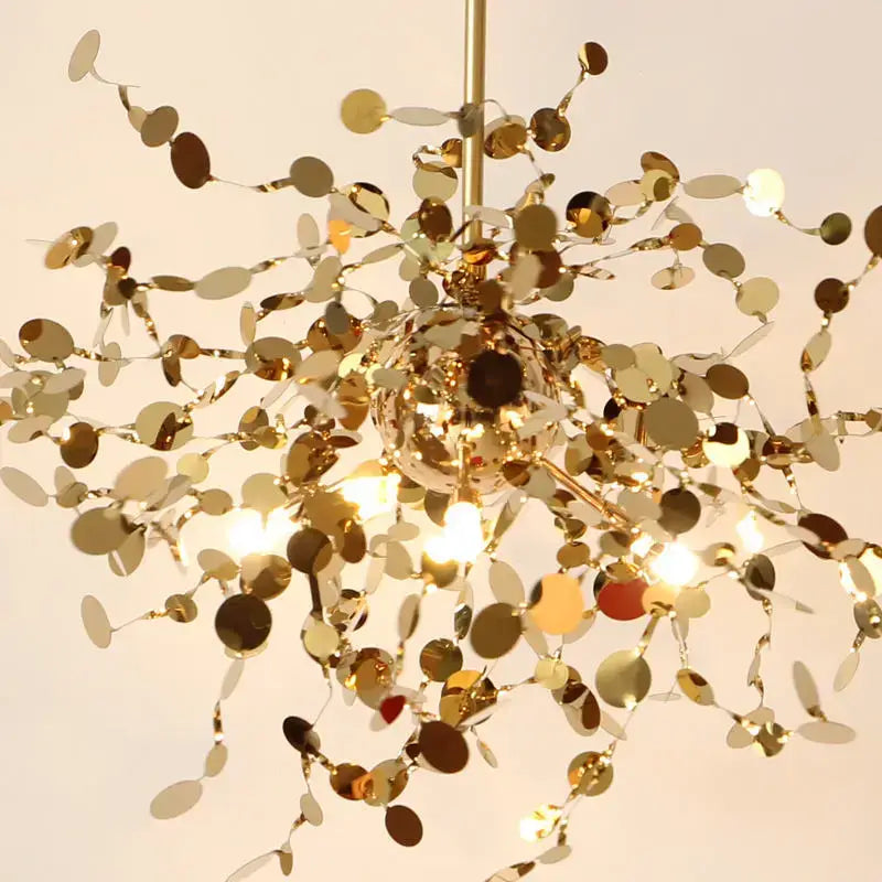 A shimmering gold decorbites dandelion chandelier with delicate branch-like arms and reflective discs for dining room light