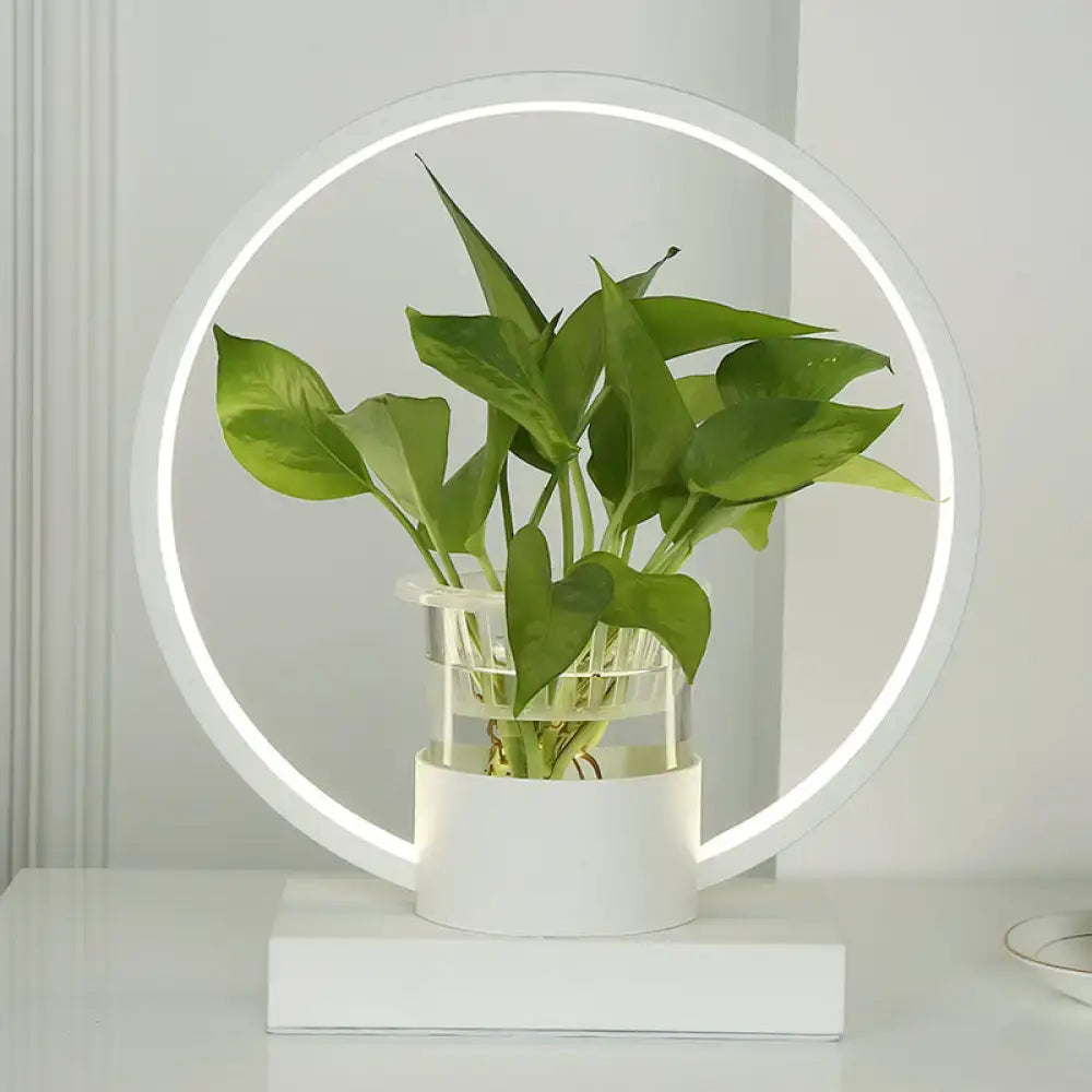 White circular DecorBites aluminum floor lamp with LED and remote control featuring a clear glass plant cup with green leaves