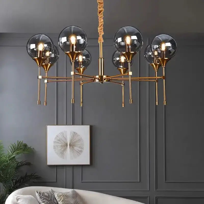 Brass-finished designer metal chandelier with six spherical smoked glass shades and twisted rope pendant for modern living