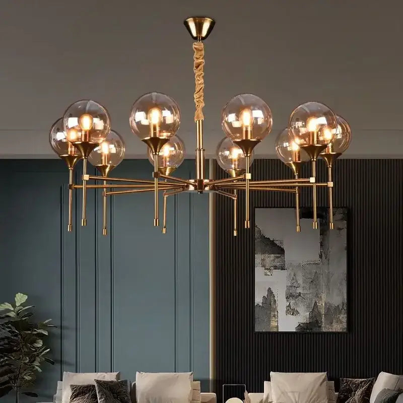 Gold-toned designer metal chandelier with multiple spherical glass shades and twisted rope-like central pendant for modern living