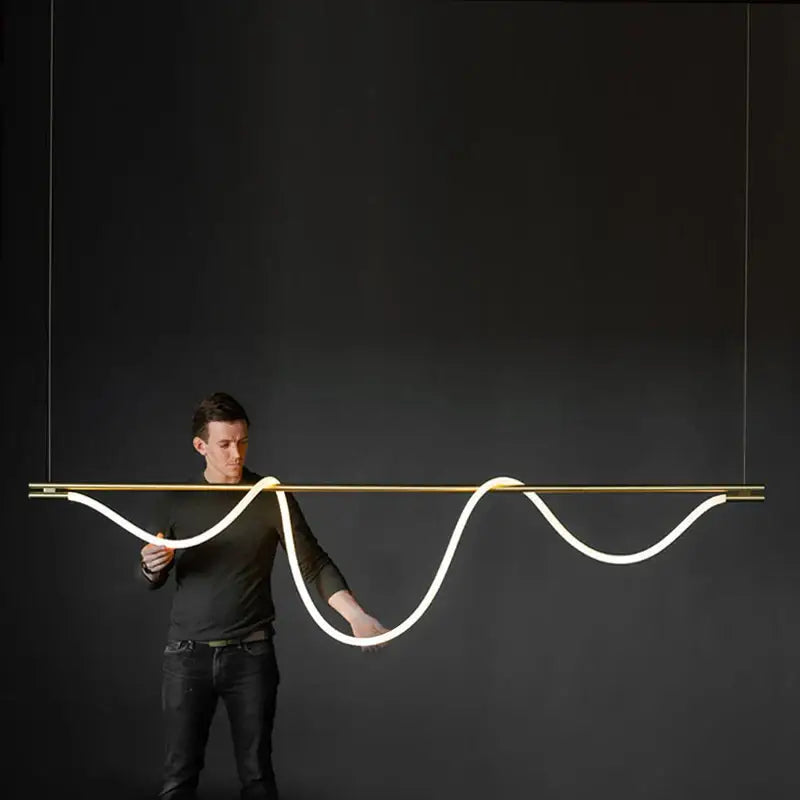 A sleek gold-toned metal nordic hose led ceiling chandelier with dimmable white led tubing for modern home decor