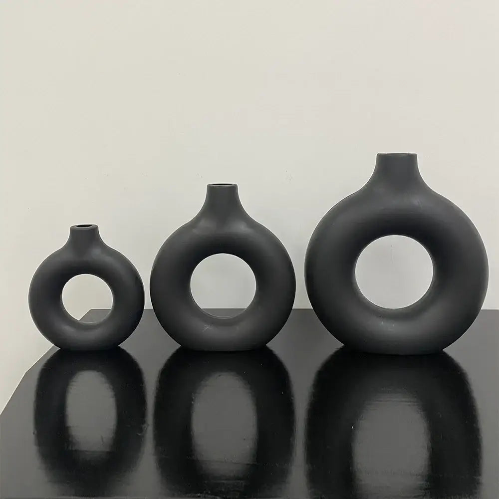 Set of three matte black ceramic donut shape flower vases with rounded bulbous bodies by decorbites minimalistic design
