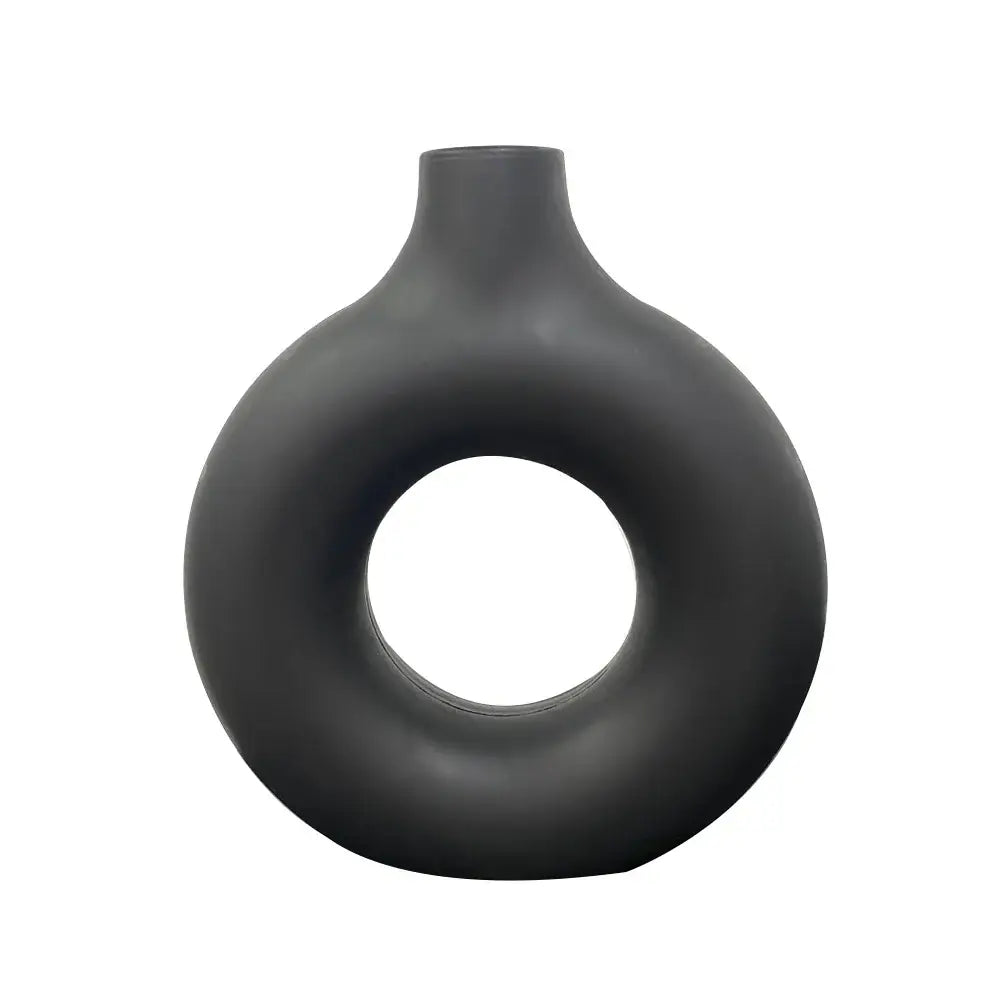 A sleek matte black ceramic donut shape flower vase with a modern minimalist design and narrow neck by decorbites