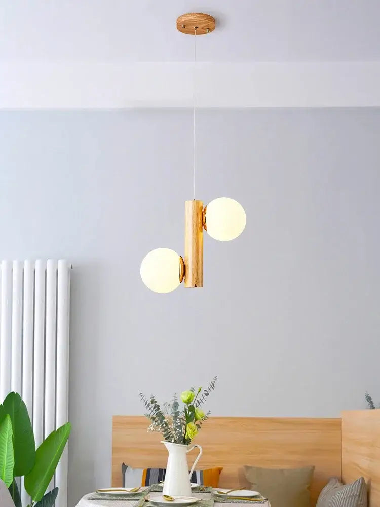 Modern gold bamboo e27 pendant lamp with two white spherical bulbs suspended from a wooden ceiling fixture
